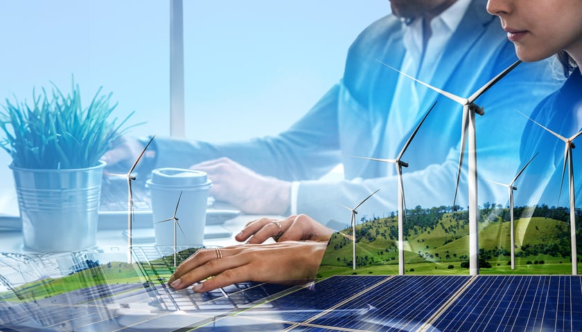 Technologie dla biznesu. Na zdjęciu panele fotowoltaiczne i wiatraki – alternatywne źródła energii. Zdjęcie ilustracyjne
