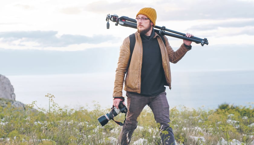 Mężczyzna ze sprzętem fotograficznym na łonie natury