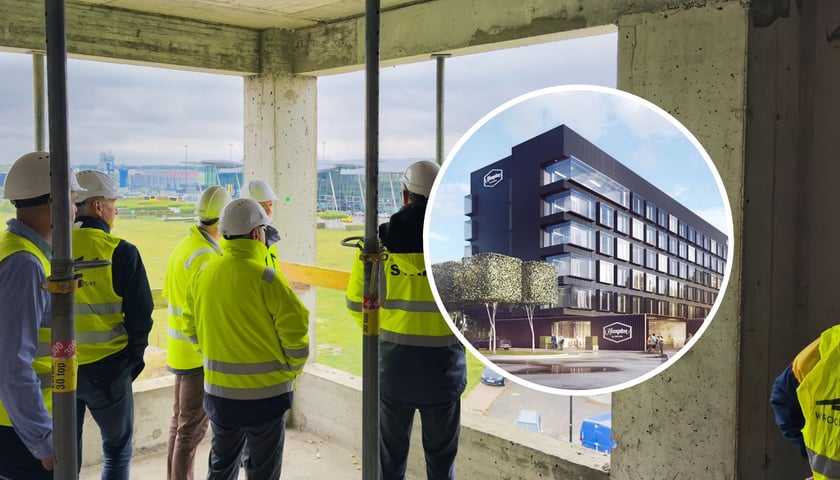 Mężczyźni w kamizelkach ochronnych i kaskach na głowie na budowie Hotel Hampton by Hilton Wrocław Airport, w kółku wizualizacja hotelu