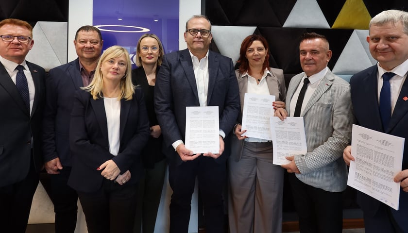 Kobiety i mężczyźni, czworo z nich trzyma w rękach dokumenty. Sygnatariusze porozumienia Beko - związki zawodowe ws. odpraw