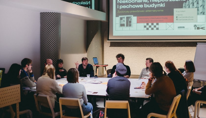 Kobiety i mężczyźni siedzą przy stole. Twórcy Mapy Znikającego Miasta