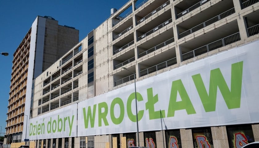 Baner z napisem „dzień dobry WROCŁAW” na częściowo rozebranej elewacji parkingu wielopoziomowego Arkad Wrocławskich (1 lipca 2025)