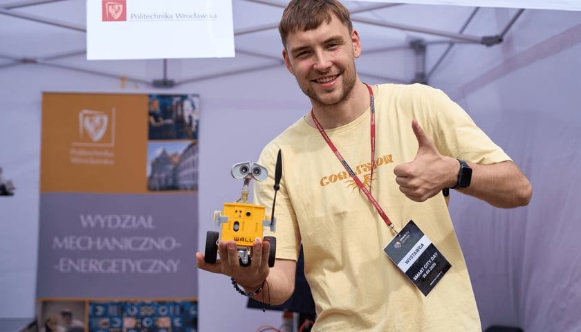 Mężczyzna trzyma w rękach małego robota (Smart City Day 2025 na placu Solnym)