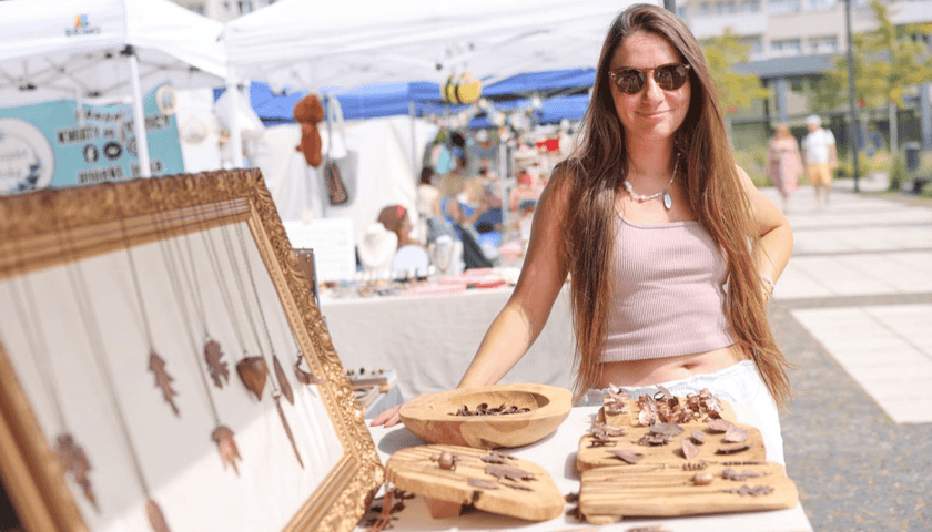 Targi rękodzieła na placu Nowy Targ. Na zdjęciu uśmiechnięta dziewczyna przy jednym ze stoisk. Zdjęcie ilustracyjne