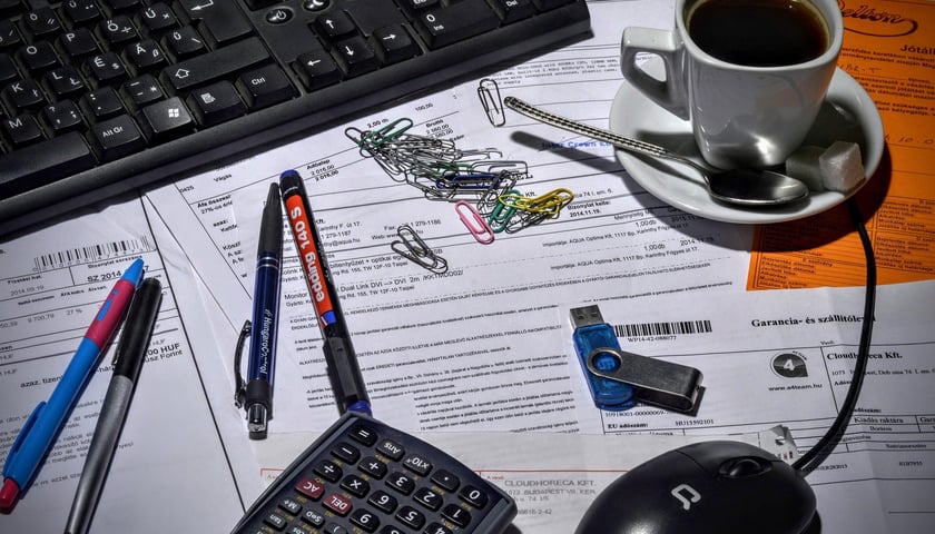 Biurko, na którym leżą dokumenty i stoi filiżanka z kawą.