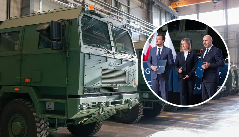 Pojazdy wojskowe produkowane w Jelczu. Dwóch mężczyzn i kobieta. Ze strony Polskiej Grupa Zbrojeniowej S.A. umowę podpisał prezes zarządu Adam Leszkiewicz, a ze strony spółki Jelcz: prezes zarządu Mariusz Ptak oraz członek zarządu Małgorzata Węgłowska – Juskowiak