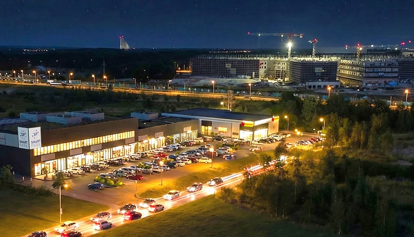 Obiekty handlowe, samochody, w tle nowy szpital onkologiczny. Smart Park budowany jest przy ul. Kamiennogórskiej (nieopodal ul. Kosmonautów), wizualizacja