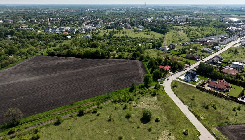 Powiększ obraz: <p>Teren rolny przy ulicy Polnej na Brochowie, o kt&oacute;ry powiększony ma zostać Park Brochowski, widok z drona. W prawym dolnym rogu zdjęcia widać zakończony ślepo zalążek nowej drogi, kt&oacute;ra prowadzić będzie do stacji kolejowej Iwiny.</p>