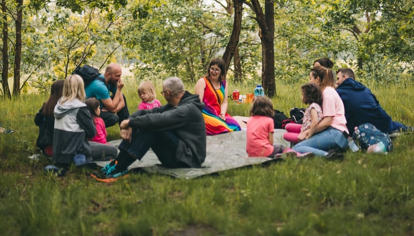 Powiększ obraz: <p>Grupka os&oacute;b na kocu piknikowym w plenerze. Wiele projekt&oacute;w w Mikrgrantach zachęca do wyjścia na zewnątrz i spędzenia czasu na dworze.</p>