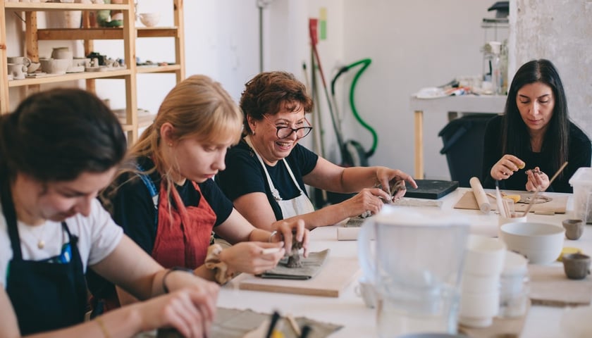 Powiększ obraz: <p>Cztery kobiety przy stole biorące udział w warsztatach ceramicznych. Zdjęcie archiwalne, wykonane podczas jednej z poprzednich edycji Mikrogrant&oacute;w.</p>