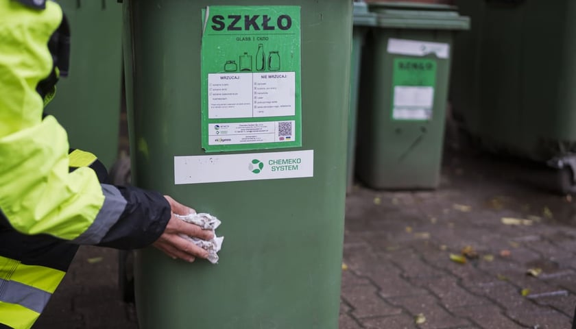 Pracownik Wrocławskiej Sp&oacute;łdzielni Socjalnej sprzątający miejsce gromadzenia odpad&oacute;w