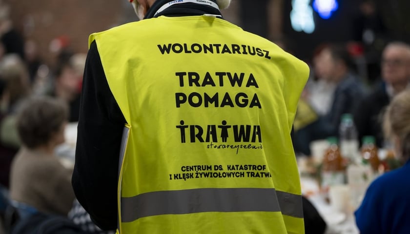 Wolontariusz w ż&oacute;łtej kamizelce, pomagający z organizacji Wigilii Pełnej Ciepła w Czasoprzestrzeni. Zdjęcie archiwalne z 2024 roku.