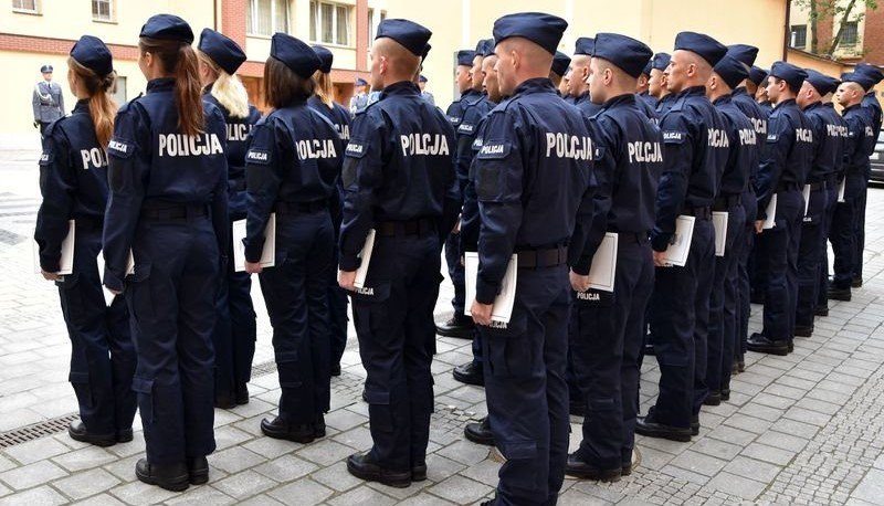 Powiększ obraz: Grupa policjantów stoi w kilku szeregach. Na przodzie kobiety, z tyłu mężczyźni