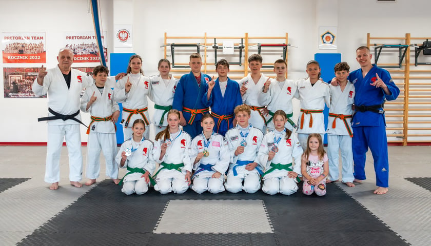 Powiększ obraz: Zawodnicy i trenerzy Pretorian Judo Team na wspólnym zdjęciu w sali gimnastycznej