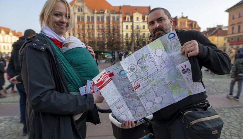 mapa z pieczątkami oraz uczestnicy WrocWalk Marthon 2021 na wrocławskim Rynku