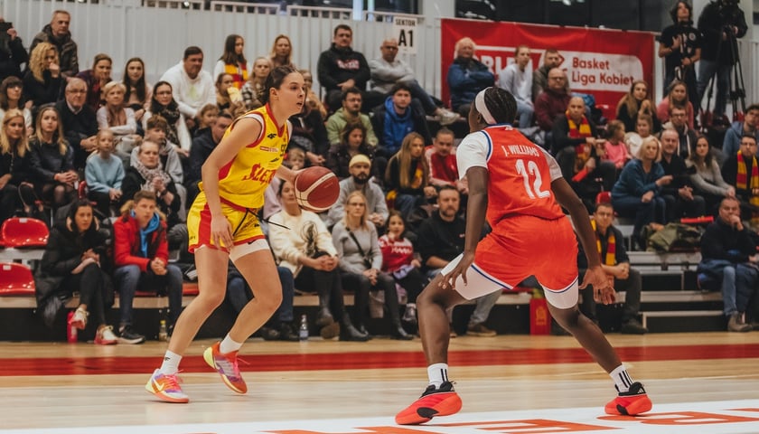 Powiększ obraz: Aleksandra Mielnicka, zawodniczka Ślęzy Wrocław z piłką w czasie meczu próbuje ominąć koszykarkę Wisły Kraków.