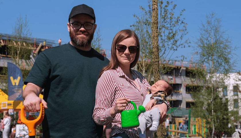 Piknik WROśnij we WROcław na skwerze Scharouna na osiedlu Leśnica - 18 kwietnia 2026 r. para z dziećmi pozuje do zdjęcia przy drzewku 