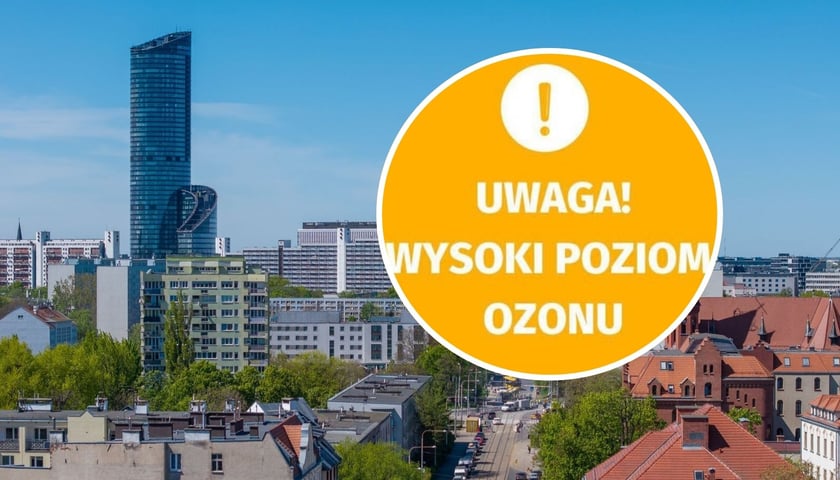 Zdjęcie ilustracyjne - widok na budynki ulice oraz Sky Tower we Wrocławiu w pogodny dzień - ujęcie z drona / w kółeczku napis "Uwaga! Wysoki poziom ozonu"