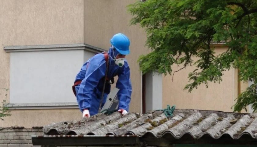 Na zdjęciu usuwanie szkodliwego azbestu przez pracownika w kombinezonie ochronnym