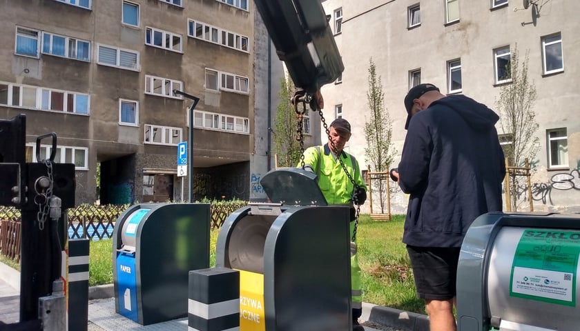 Wyciąganie podziemnego pojemnika na odpady na podwórku w okolicach pl. Nowy Targ i pl. Nankiera