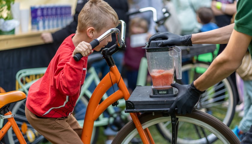 Chłopiec jeździ na rowerze i miksuje sok w blenderze podczas poprzedniej edycji Soboty z Zielonym Wrocławiem