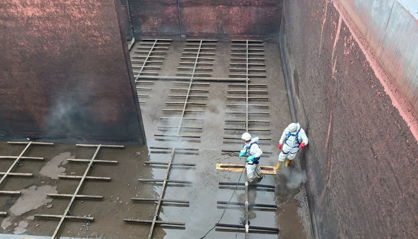 W pierwszej kolejności ścieki trafiają do oczyszczania mechanicznego na kratach, piaskownikach i osadnikach  - na zdjęciu widać pracę dwóch osób przy tym procesie