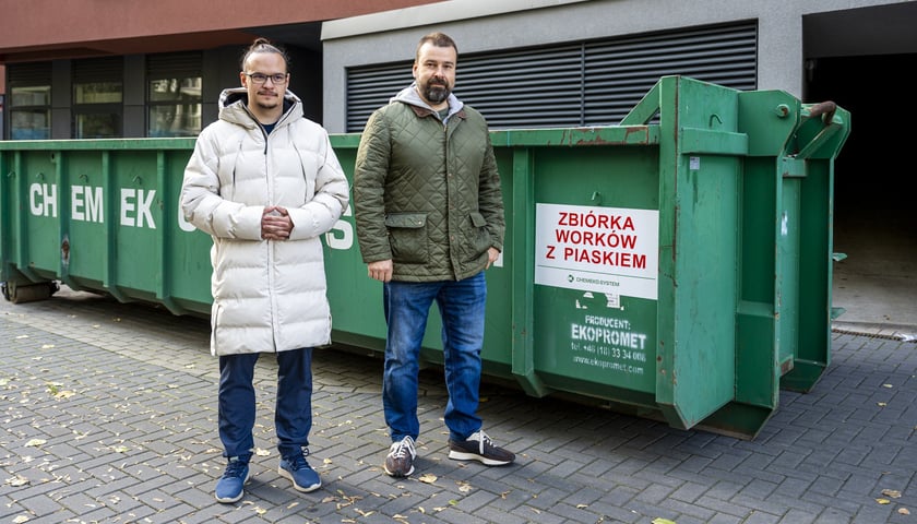 We Wrocławiu stanęły kontenery na worki z piaskiem. Na zdjęciu od lewej Piotr Krejner, rzecznik prasowy Ekosystemu oraz Paweł Karpiński, wiceprezes Ekosystemu, w tle kontener na worki z piaskiem przy ul. Białowieskiej