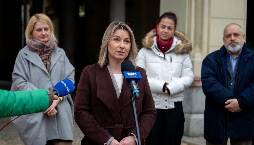 Katarzyna Szakowska z Ekostraży - kobieta stoi przy mikrofonie, z tyłu widać innych ludzi 
