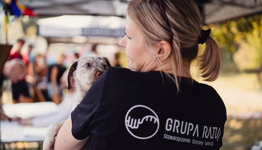 Wolontariuszka z Grupy Ratuj trzymająca na rękach psa - piknik 2024