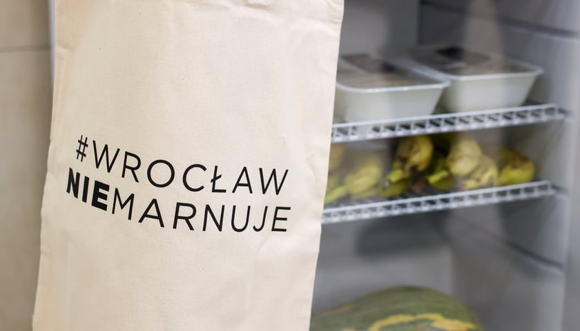 Lodówka społeczna z przewieszoną na niej torbą. Na torbie napis: #WROCŁAW NIE MARNUJE.