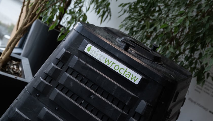 Czarny kompostownik z napisem na białym tle "eko Wrocław".