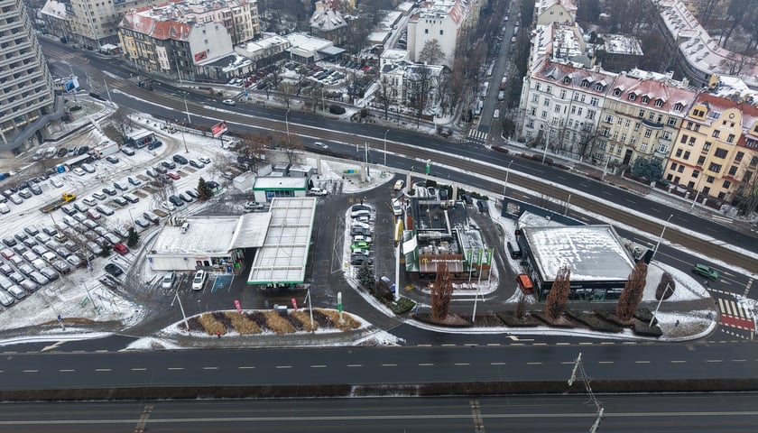 Widok na działkę z budynkami przeznaczonymi do rozbiórki: stacją paliw, restauracją i pawilonem (luty 2026)