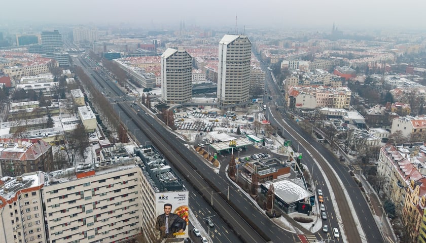 Widok na działkę z budynkami przeznaczonymi do rozbiórki: stacją paliw, restauracją i pawilonem (luty 2026)