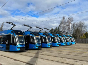 Na zdjęciu znajdują się niebieskie, niskopodłogowe tramwaje w zajezdni.
