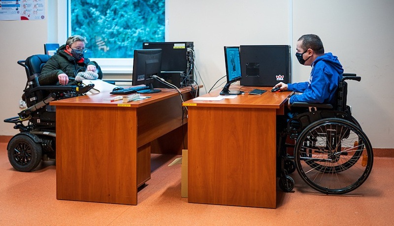 osoby na wózkach inwalidzkich przy stanowiskach komputerowych