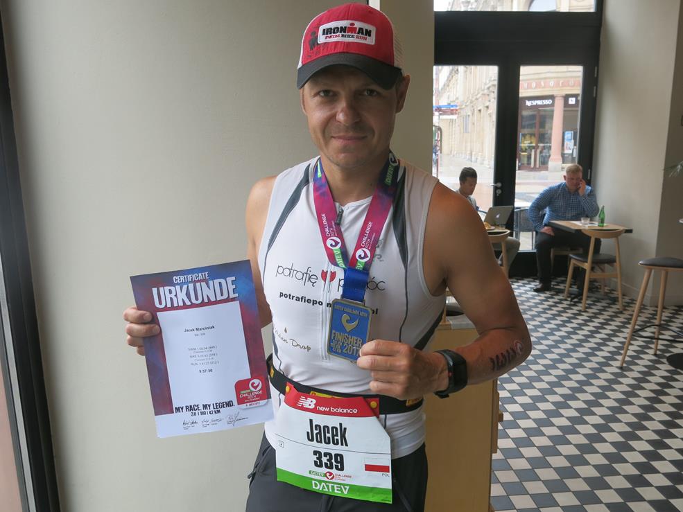 Jacek Marciniak z medalem i certyfikatem ukończenia wyścigu